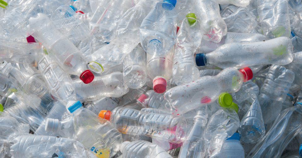 Piles of plastic water bottles as a result of increased global waste production