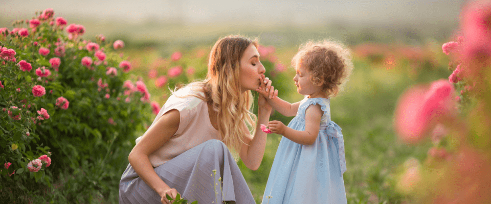 Image of mother and daughter sharing a special moment in a rose garden.