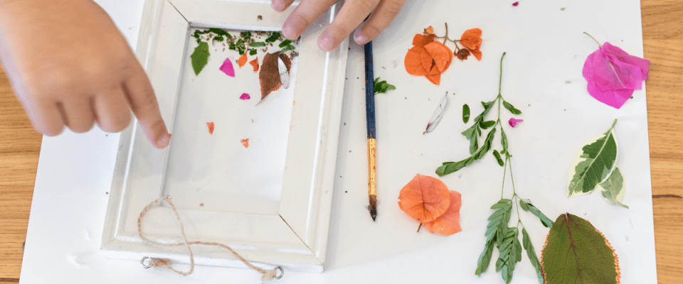 Image of child crafting a pressed flower botanical art project.