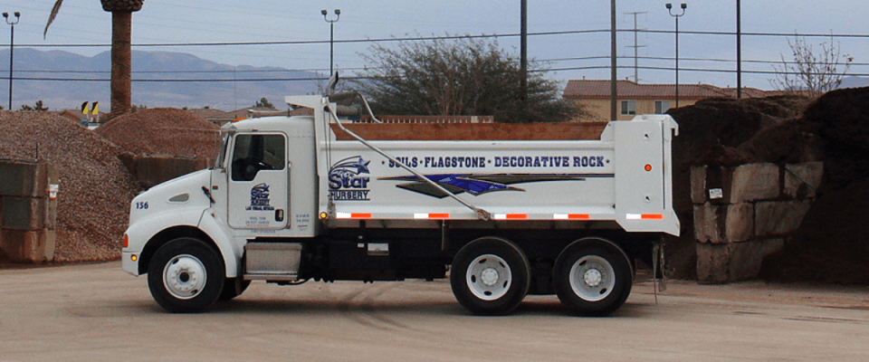Star Nursery rock truck in front of rock yard bins filled with rock and soils